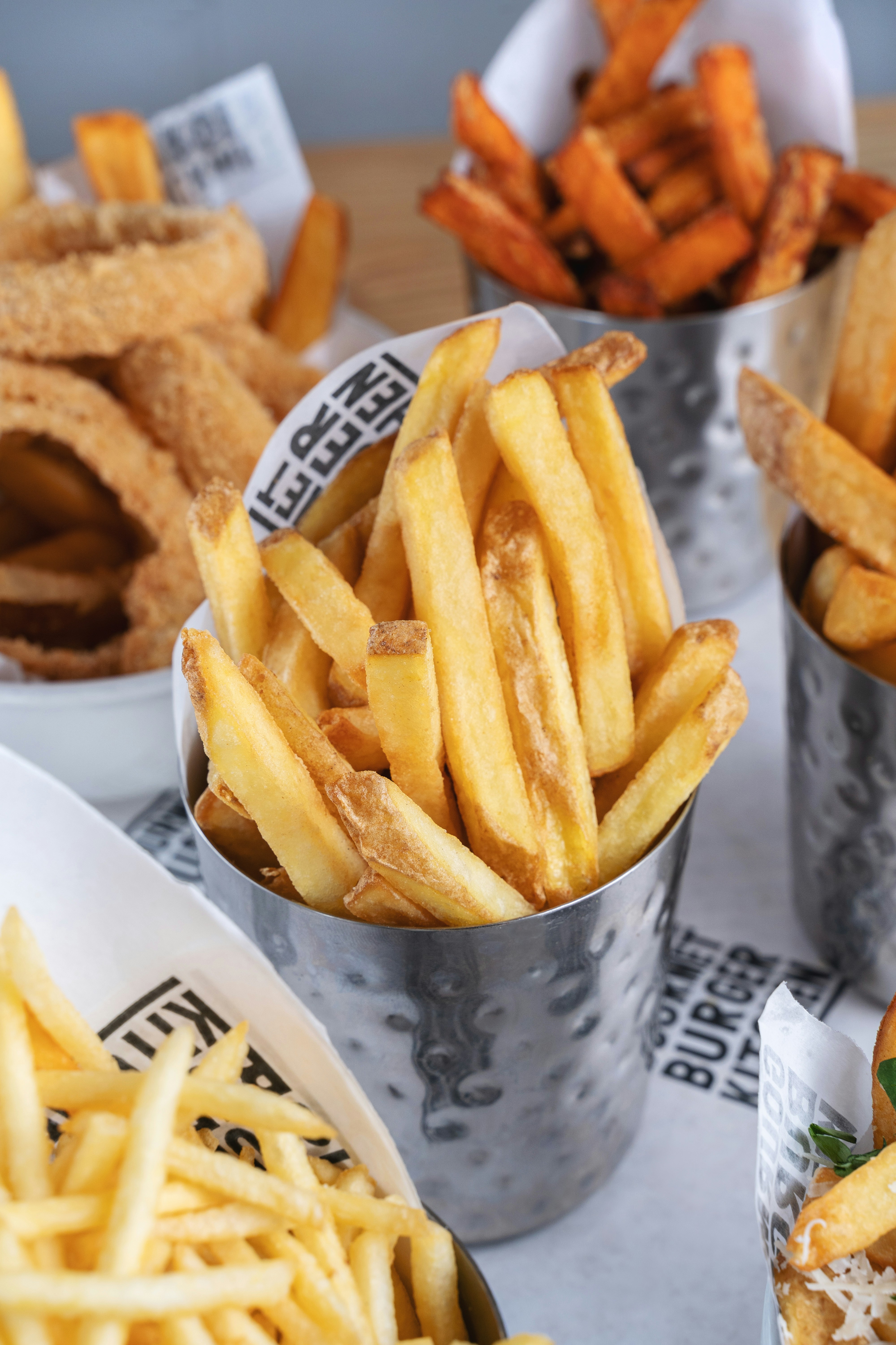 A serving of perfectly crispy, golden French fries in a basket with dipping sauce.